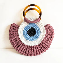 Detalhes da bolsa Olho Grego em crochê sintético, destacando textura, acabamento e design do amuleto
