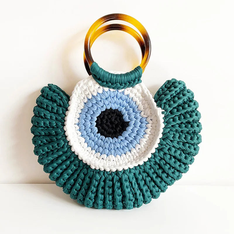 Detalhes da bolsa Olho Grego em crochê sintético, destacando textura, acabamento e design do amuleto