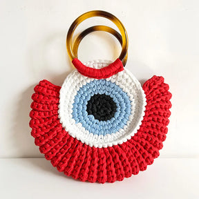 Detalhes da bolsa Olho Grego em crochê sintético, destacando textura, acabamento e design do amuleto