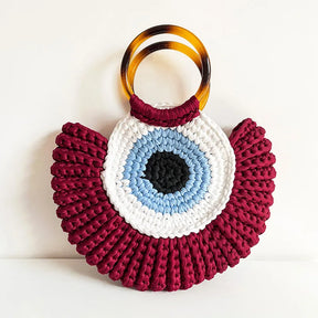 Detalhes da bolsa Olho Grego em crochê sintético, destacando textura, acabamento e design do amuleto