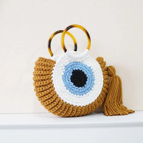 Detalhes da bolsa Olho Grego em crochê sintético, destacando textura, acabamento e design do amuleto
