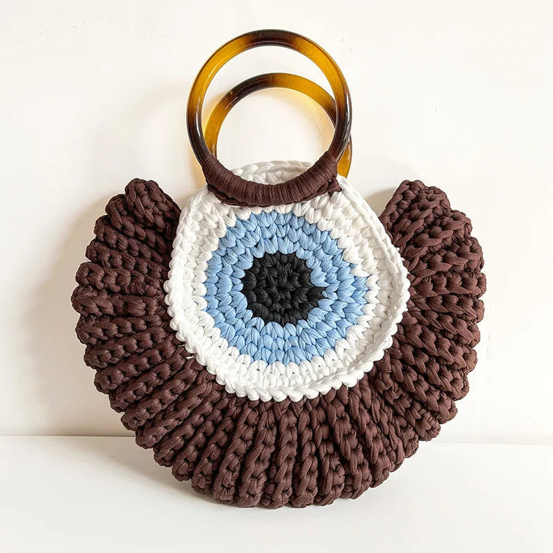 Detalhes da bolsa Olho Grego em crochê sintético, destacando textura, acabamento e design do amuleto